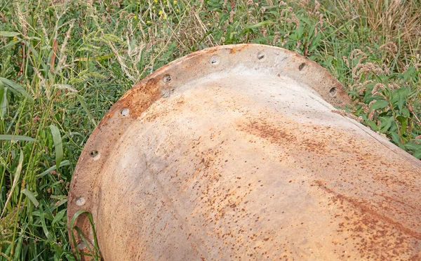 Çimlerin üzerinde aşınmış büyük bir boru, seçici bir odak noktası.