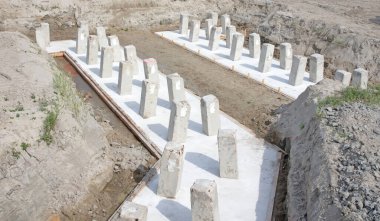 İnşaat alanındaki yeni bir bina için beton yığınları - temel inşaatı için zemin altındaki beton yığını