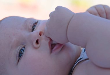 Ağzında başparmağı olan güzel bir bebek, seçici bir odak.