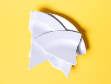 Katı sarı arka planda kırık beyaz plaka.