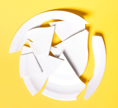 Katı sarı arka planda kırık beyaz plaka.