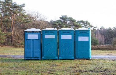 Hollanda ormanlarında peş peşe dört seyyar tuvalet.