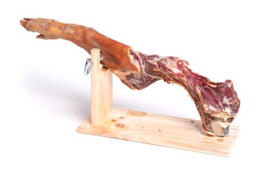 İspanyol jamon serrano bacağı, kuru jambon, beyaz arka planda, yarısı yenmiş.