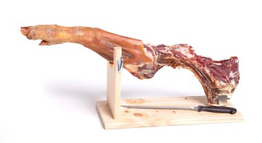 İspanyol jamon serrano bacağı, kuru jambon, beyaz arka planda, yarısı yenmiş.