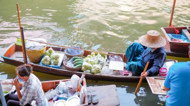 Ratchaburi  Thailand - April 15 2022 : Group of boat selling Thai fruit and food at ancient travel destination of Thailand Damnoen saduak flating market, Ratchaburi Thailand.