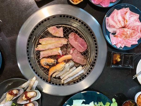 可在炉灶上烤牛肉和猪肉的顶视图套餐提供韩式烧烤 — 图库照片