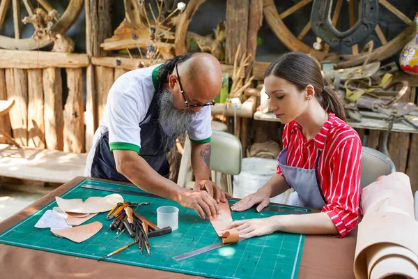 stock image Team of leathers maker is drawing a design on leather in leather workshop.