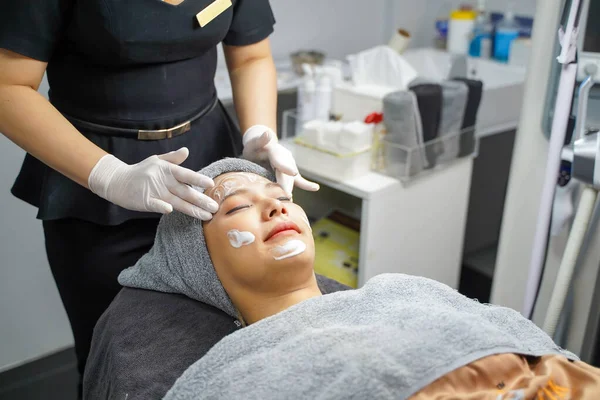 Stock image Young beauty woman in towel making facial massage with organic face scrub.