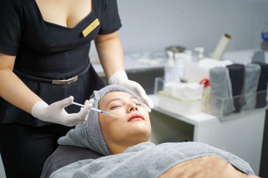 Yakından Asyalı güzeller güzellik kliniklerindeki kozmetologlardan yüz serumları alırlar. Güzellik ten konsepti.
