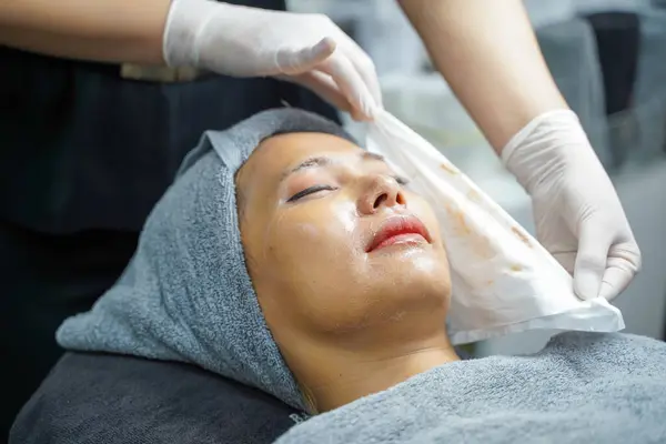 Closeup cosmetologists cleaning the face of Asian beauty woman before making face spa and facial mask.