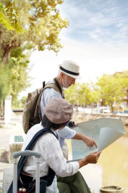 Tur rehberiyle yakın plan Amerikalı turist şehir arka planındaki bulanık turistik yerleri bulmak için şehir haritalarına bakıyor. Kıdemli turist konsepti