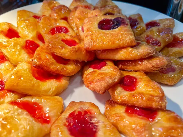 Closeup and crop Homemade Danish pastry yeasted dough with Strawberry Jam on white ceramic plate sell on bakery shop.