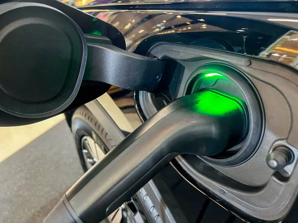 Closeup electric plug charging to EV car at at Electric vehicle charging station