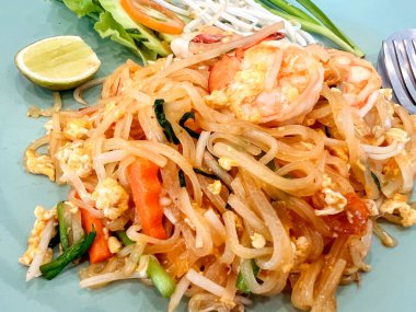 Yakın çekim ve üst manzara taze kızartılmış Tayland karidesli Tayland eriştesi tarifi geleneksel kaplama seramik tabakta..