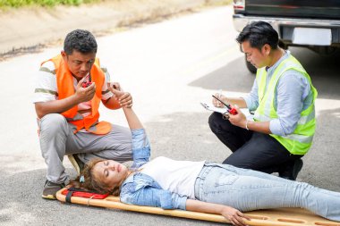 Yakından kurtarma ekipleri telsiz iletişimini kullanarak kadın sürücülere trafik kazasında yardım ediyorlar..