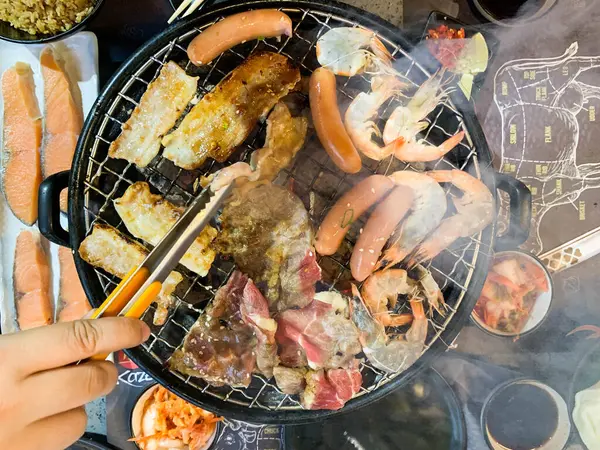 Japon deniz ürünleri ve siyah arka planda et ızgarası olan çeşitli birinci sınıf yakiniku manzarası..