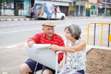 Avrupalı arkadaşıyla birlikte kıdemli Çinli turist rahatça konuşuyor ve sabah Chiang Mai 'de turistlerin ilgisini çekiyor..