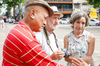Son sınıf turist grubu Chiang Mai şehrindeki turistik yerleri bulmak için şehir haritalarına bakıyor..