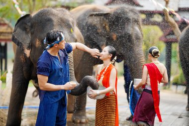 Tayland 'ın kuzeyindeki Tayland' lı genç adam Tayland 'da Songkran su festivali, Chiang Mai, Tayland' da filli güzel bir Taylandlı kadının yanağına pudra sürüyor.