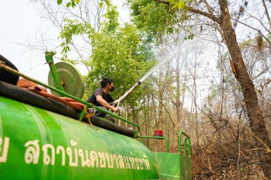 Lampang, Tayland - 04 Nisan 2023: Fil Koruma Örgütü 'nden yakın çekim su topları simüle edilmiş orman yangınında duman ve yangını söndürmek için su püskürtüyor