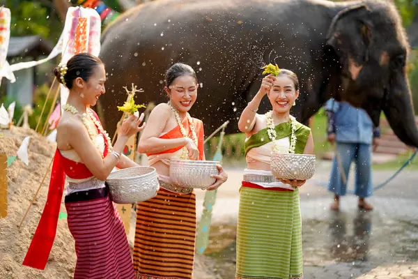 Tayland 'ın geleneksel elbiseleriyle Tayland Yeni Yıl Festivali' nde su serpmek için çalan bir grup güzel Taylandlı kadın ya da Songkran festivali..