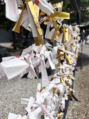 Tokyo şehri, Japonya-13 Aralık 2024: İnsanların bir tahminde bulunmak için kullandığı Omikuji 'nin yakın çekim ve perspektif görüntüsü. Eğer kehanet kötüyse, kötü şansı defetmek için tapınağa bırakılır..