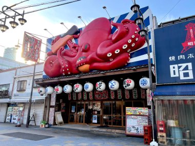Osaka şehri, Japonya-07 Aralık 2024: Shinsekai bölgesinde deniz ürünleri ızgarası şeklinde ilginç bir Japon restoranı tabelası. Shinsekai bölgesindeki Japon restoranı yabancı turistler için popülerdir.