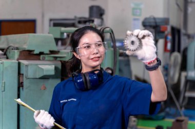 Kapalı Asyalı kadın teknisyen. Endüstriyel atölyedeki küçük teçhizatı kontrol edin..