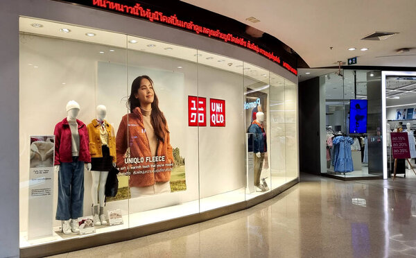 BANGKOK, THAILAND - NOVEMBER 8, 2022 : Front of Uniqlo store. Luxury and fashionable brand window display. Winter collection Welcoming the Christmas Festival. Wide screen capture.