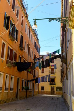 Typical city corner with ancient colorful buildings Drying clothes on a clothes-line in outdoor at sunny summer day. Venice, Ital