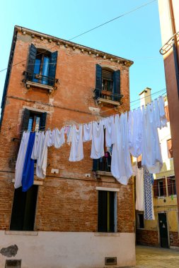 Typical city corner with ancient colorful buildings Drying clothes on a clothes-line in outdoor at sunny summer day. Venice, Italy