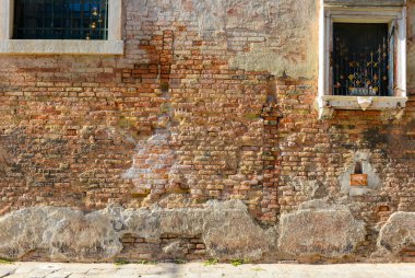 White window on old house wall Cracks in concrete visible red bricks in Venice, Italy