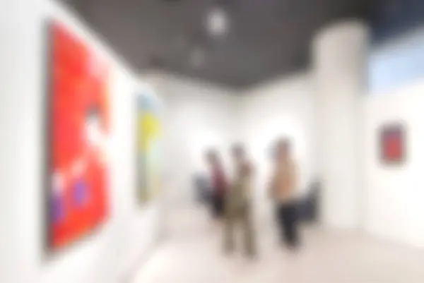 Art exhibition gallery blurry background and People looking at paintings on white wall