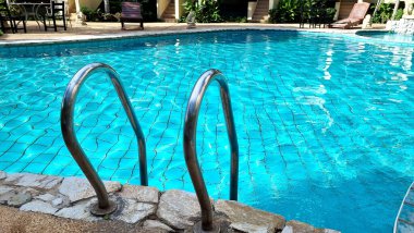 Parlak mavi bir yüzme havuzundaki korkuluklar