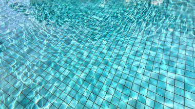 Parlak mavi bir yüzme havuzundaki yansıma.