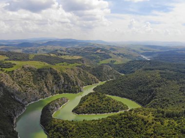 Uvac nehrinin hava manzaralı yolları. Güneşli bir günde güzel bir nehir ve dağın üzerinde uçuyorum. Hava aracı görüntüsü, manzara manzarası. River ve Lake Uvac, Sırbistan