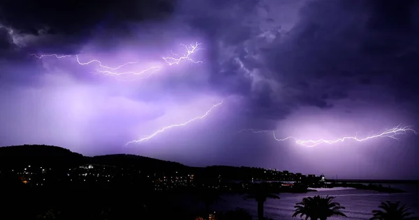 亚得里亚海上空的雷雨 夜空中闪电般闪烁着闪电 夜晚的城市景观轮廓 黑山律师协会 图库图片