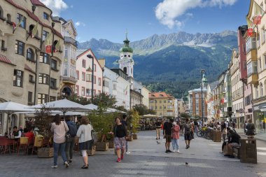 INNSBRUCK, AUSTRIA - 30 Temmuz 2022: Eski Şehir Meydanı, Maria-Theresien-Caddesi, Innsbruck, Kutsal Ruh Hastanesi Kilisesi, Almanca Spitalskirche, arka planda