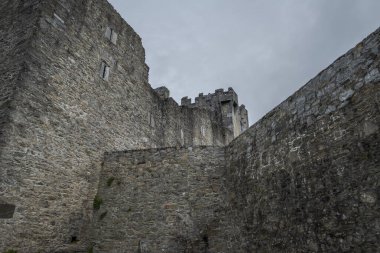 KERRY, IRELAND - 8 AĞUSTOS 2023 İrlanda 'da Ross Kalesi, yıpranmış taş siperleri ve bulutlu gökyüzü