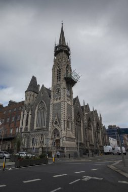 DUBLIN, IRELAND - 10 AĞUSTOS 2023: Dublin 'deki Findlaters Kilisesi olarak bilinen Abbey Presbiteryen Kilisesi, bulutlu bir gökyüzü altında yakalanan belirgin bir kule ve karmaşık Gotik Diriliş mimari detaylarına sahiptir.