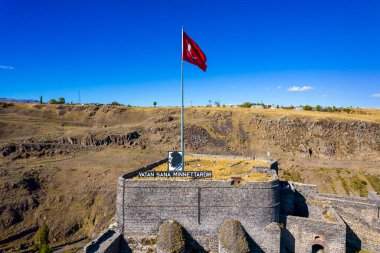 Kars, Türkiye - 25 Ekim 2022: Kars Şatosu (Türkçe: Kars Kalesi) mavi gökyüzü manzaralı. Şato, Türkiye 'nin Kars kentinde bulunan eski bir kaledir. Güzel hava manzarası. İHA atışı.