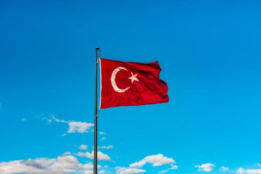 Mavi gökyüzünde dalgalanan Türk bayrağı.