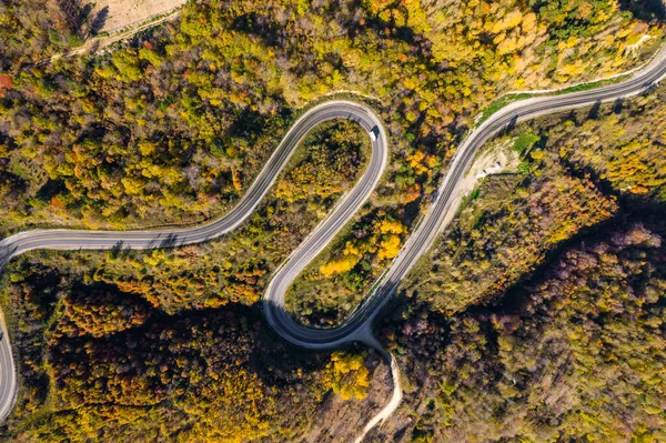 stock image Winding road through the forest. Beautiful autumn landscape with winding road. Aerial drone shot.