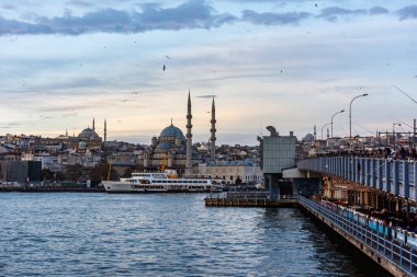 İstanbul, Türkiye - 3 Aralık 2023: Galata Köprüsü ve İstanbul 'daki Yenicami Camii (Yeni Cami). Güzel İstanbul Boğazı güneş doğumu manzarası. Sabahları inanılmaz renkli gökyüzü. 