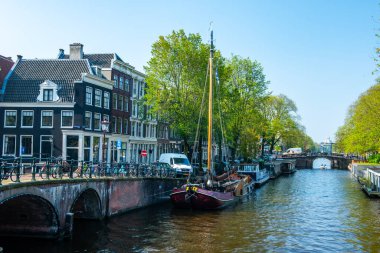 AMSTERDAM, NETHERLANDS - 25 Eylül 2017 Amsterdam Şehir Merkezi. Köprüsü olan Amsterdam Kanalları ve tipik Hollanda Evleri 'nin güzel manzarası. Amsterdam, Hollanda. 