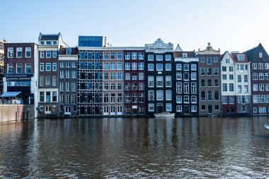 AMSTERDAM, NETHERLANDS - 25 Eylül 2017 Amsterdam Şehir Merkezi. Köprüsü olan Amsterdam Kanalları ve tipik Hollanda Evleri 'nin güzel manzarası. Amsterdam, Hollanda. 