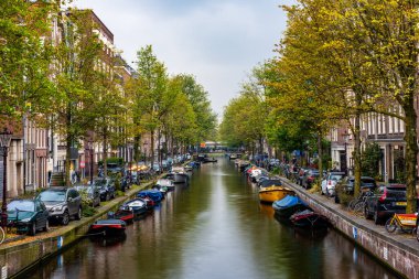 AMSTERDAM, NETHERLANDS - 25 Eylül 2017 Amsterdam Şehir Merkezi. Köprüsü olan Amsterdam Kanalları ve tipik Hollanda Evleri 'nin güzel manzarası. Amsterdam, Hollanda. 