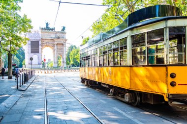 MILANO, İtalya - 3 Temmuz 2019: Milano, İtalya 'da nostaljik sarı tramvayla Barış Kemeri (Arco della Pace) manzarası.