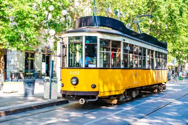 MILANO, İtalya - 3 Temmuz 2019: Milano, İtalya 'da nostaljik sarı tramvayla Barış Kemeri (Arco della Pace) manzarası.