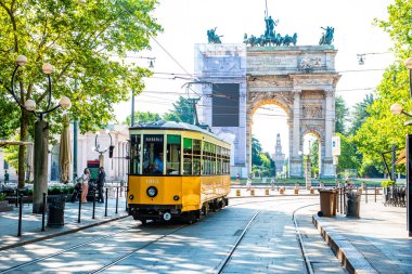 MILANO, İtalya - 3 Temmuz 2019: Milano, İtalya 'da nostaljik sarı tramvayla Barış Kemeri (Arco della Pace) manzarası.